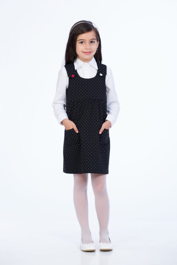 Sarafan negru cu buline albe pentru şcoală, cu buzunare şi nasturi. Potrivit ca îmbrăcăminte sau ţinută şcolară, uniformă şcolară, pentru copii, elevi, fetite, fete. Fabricat în România.